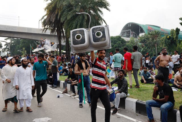 <p>People carry looted items from the prime minister's residence in Dhaka</p>