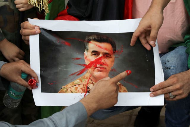 <p>File: Afghans paint over a picture of Lt General Faiz Hameed as they hold a protest against Pakistan in New Delhi, India</p>