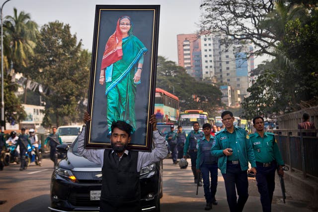 <p>Supporter of Awami League party carries a portrait of Sheikh Hasina during an election rally in Dhaka in 2018</p>