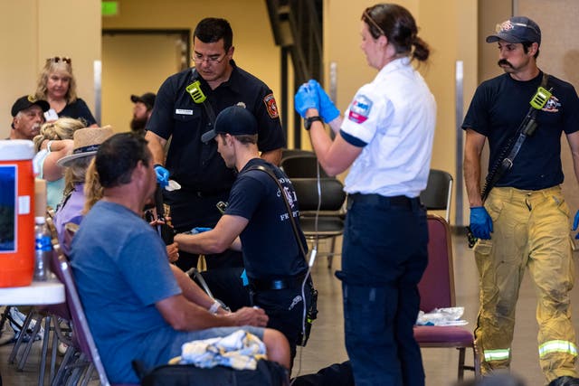 <p>Members of the Colorado Springs Fire Department and AMR paramedics treat people for heat-related illness at the Pikes Peak Regional Airshow</p>