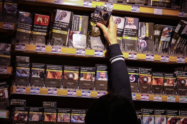 <p>A tobacco shop employee takes rolling tobacco pack, in Toulouse, south-western France, on September 30, 2022</p>