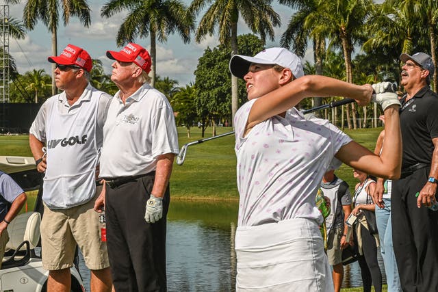 Former US President Donald Trump (2nd L) watches his granddaughter, Kai Trump, play golf at Trump National Doral Miami golf club on October 27, 2022 in Miami, Florida, a day ahead of the 2022 LIV Golf Invitational Miami