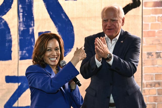 <p>Vice President and Democratic presidential candidate Kamala Harris (L) speaks as her running mate Minnesota Governor Tim Walz looks on during a stop on their campaign bus tour in Rochester, Pennsylvania, on August 18, 2024</p>