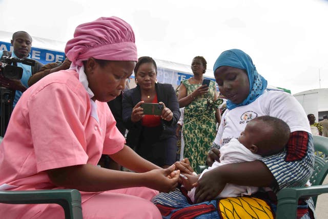 <p>A health worker administers the malaria vaccine Oxford-Serum R21 to a child in Abidjan</p>