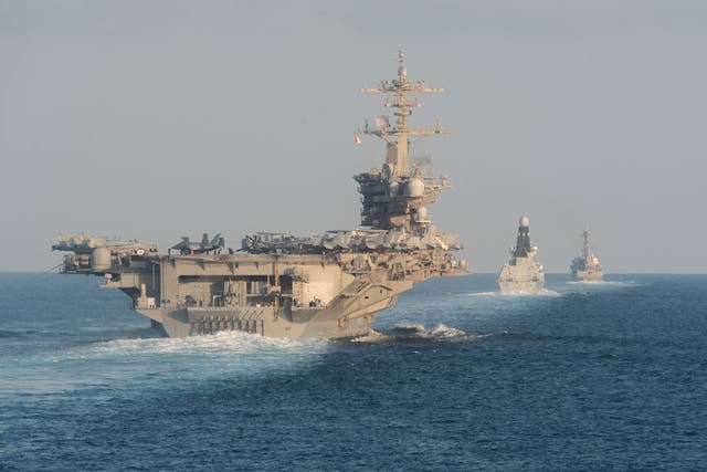 <p>The aircraft carrier USS Abraham Lincoln, left</p>