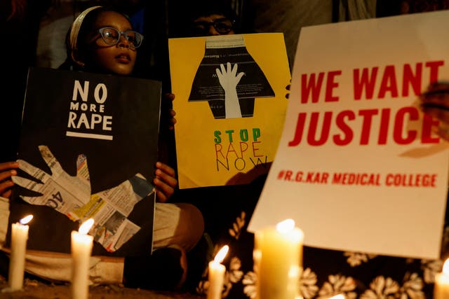 <p>People hold posters during a vigil condemning the rape and murder of a trainee medic at a government hospital in Kolkata, on a street in Mumbai, India, on 14 August 2024</p>