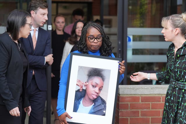 <p>Abimbola Duyile holds a picture of her daughter Hannah Jacobs outside East London Coroner’s Court on Friday </p>