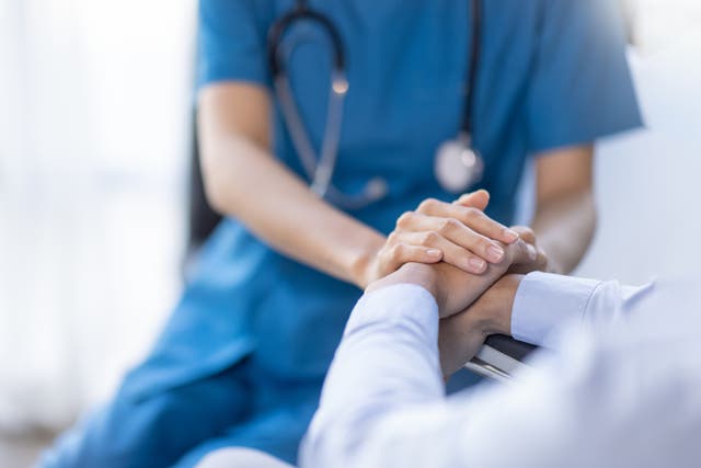 <p>A female nurse hold her senior patient's hand (stock image) </p>