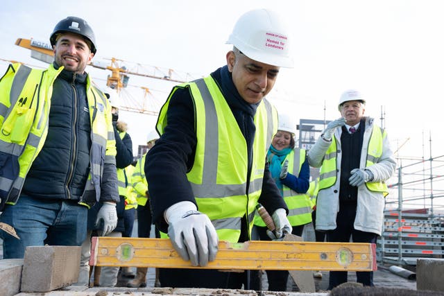 <p>Mayor of London Sadiq Khan tries his hand at bricklaying during the topping out ceremony of a new affordable housing development in the Royal Docks, east London</p>