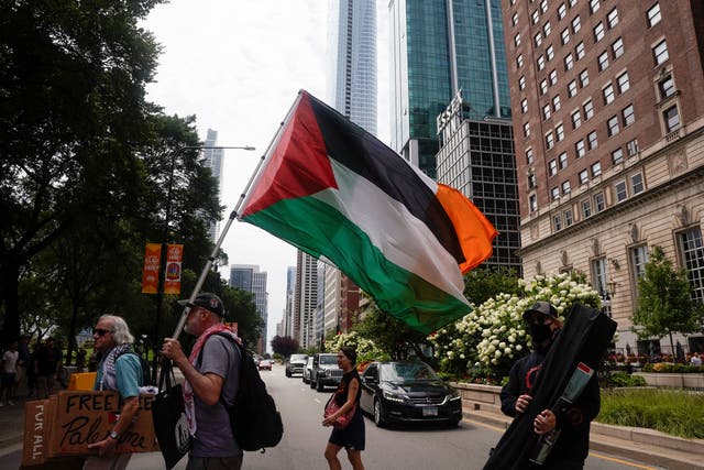 <p>Demonstrators protest against the participation of Donald Trump in the National Association of Black Journalists convention, outside the venue in Chicago while holding Palestinian flag on July 31. The city is preparing for tens of thousands of pro-Palestine protesters during the DNC </p>