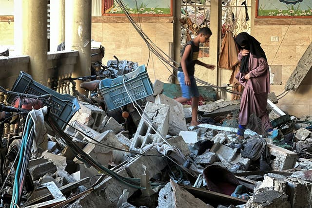 <p>Palestinians inspect the damage done to a school after an Israeli strike left scores dead last week </p>