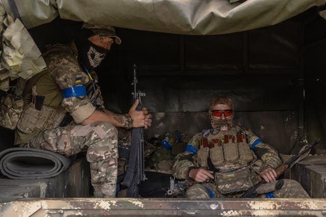 <p>Ukrainian soldiers wait in a military vehicle near the border with Russia</p>