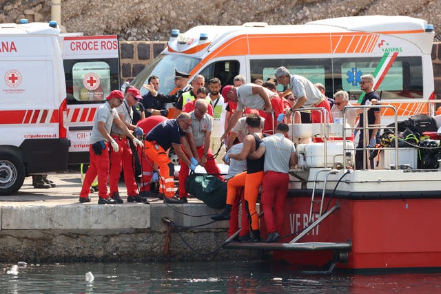 <p>Emergency services carry a body bag after the sailboat sank in the early hours of Monday off the coast of Porticello near the Sicilian city of Palermo in Italy</p>